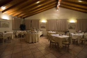a dining room with white tables and chairs and curtains at Hotel Adda in Spino dʼAdda