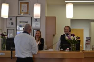 a man and a woman standing at a reception desk at Altstadthotel Arte in Fulda