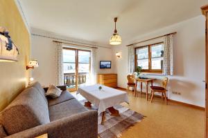 a living room with a couch and a table at Gästehaus-Bauernhof Buchwieser in Unterammergau