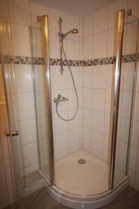 um chuveiro com uma porta de vidro na casa de banho em Gasthaus Römer em Haigerloch