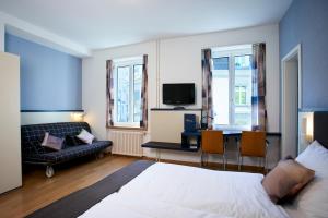 a bedroom with a bed and a desk with a television at Hotel Bristol Zurich in Zürich