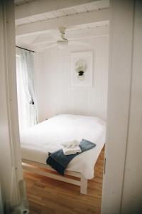 a small bedroom with a white bed and a window at RELAX PORT in Bigauņciems