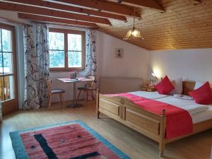 - une chambre avec un grand lit et une table dans l'établissement Ferienwohnungen Pension Sonnblick, à Krumbach