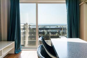 濟州的住宿－jeju Tovice Condo Ocean，客房设有桌椅和大窗户。