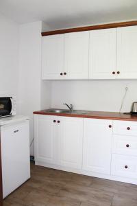 una cucina con armadi bianchi e lavandino di Apartmany St. Maria a Staré Hory