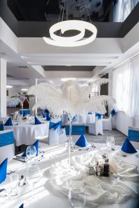 un comedor con mesas blancas y sillas azules en Hotel Horyzont, en Rzeszów