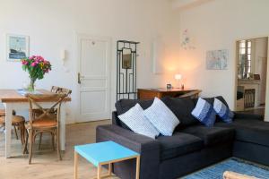 ein Wohnzimmer mit einem Sofa und einem Tisch in der Unterkunft Key to Bordeaux - fairytale view, 2 bd + elevator in Bordeaux