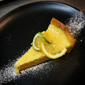 een stuk voedsel op een zwarte plaat met citroenschijfjes bij Hotel Auberge Edelweiss in La Grave +56 foto's