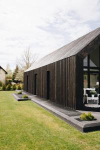 un edificio de madera con dos puertas en un patio en RELAX PORT en Bigauņciems