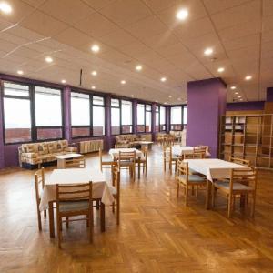 - une salle à manger avec des tables, des chaises et des fenêtres dans l'établissement TVM Tower Modřany, à Prague