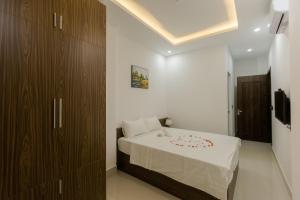 a bedroom with a bed and a brown cabinet at Bamboo Green Hotel in Dong Hoi