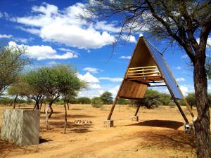 une cabane dans les arbres au milieu d'un champ dans l'établissement Ovita Wildlife Restcamp, à Okazize