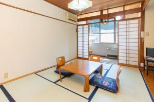 a dining room with a table and chairs in a room at Tabist Hana Hotel Takinoya Aizu-Yanaizu in Yanaizu