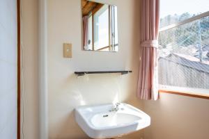 a bathroom with a sink and a window at Tabist Hana Hotel Takinoya Aizu-Yanaizu in Yanaizu