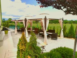 a patio with a gazebo and tables and chairs at Hotel-Clinic Dr. Gechevi in Pavel Banya