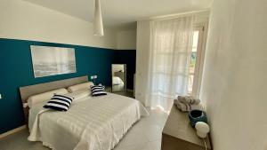 a bedroom with a bed with blue walls and a window at Appartamento 23 - bilocale vista lago in Toscolano Maderno +32 photos