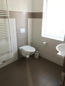 a white bathroom with a toilet and a sink at Landgasthof Schwabhausen in Schwabhausen