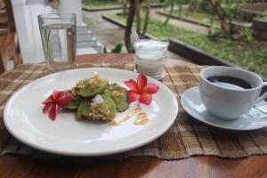 talerz jedzenia i filiżankę kawy na stole w obiekcie Intan Guest House w mieście Ubud