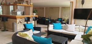 a living room with couches and blue pillows at Hotel Corallo in Fregene