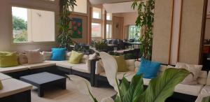 a lobby with couches and tables and plants at Hotel Corallo in Fregene