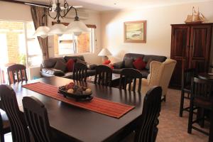 a kitchen and living room with a table and chairs at DuneSide Guest House in Richards Bay