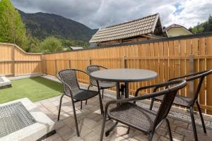 a patio with chairs and a table and a fence at Vila Vita Apartments in Kranjska Gora
