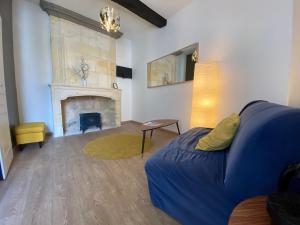 a living room with a blue couch and a fireplace at Logis des Jurats in Saint-Émilion