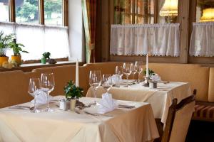 a dining room with two tables with wine glasses at Suitehotel Kleinwalsertal in Hirschegg