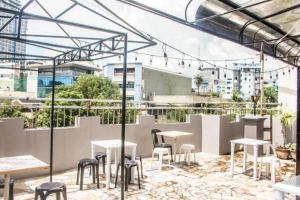 a patio with tables and chairs on top of a building at Bunks Hostel in Cebu City