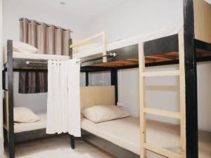 a room with two bunk beds and a ladder at Bunks Hostel in Cebu City