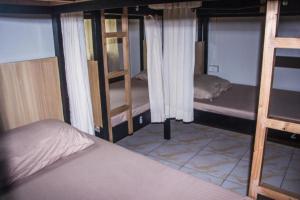 a room with three bunk beds and a ladder at Bunks Hostel in Cebu City
