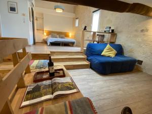 a living room with a blue couch and a bed at Logis des Jurats in Saint-Émilion