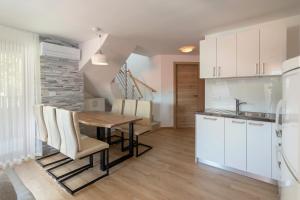 a kitchen and dining room with a wooden table and chairs at Vila Vita Apartments in Kranjska Gora