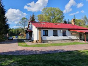 una pequeña casa blanca con techo rojo en Newland Wójtowicz, en Torzym