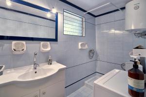 y baño blanco con lavabo y ducha. en Villa Manthos, en Avdhellás