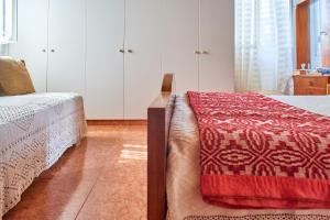 1 dormitorio con 2 camas y manta roja en Villa Manthos, en Avdhellás