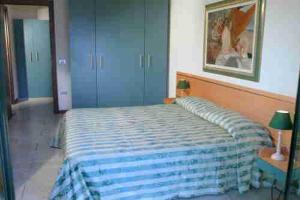 una camera da letto con un letto con una coperta blu sopra di Residence Spiaggia D'Oro a Desenzano del Garda