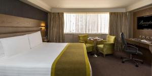 a hotel room with a bed and a table and chairs at Bonnington Hotel & Leisure Centre in Dublin