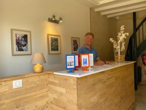 a man standing at a counter in a room at Logis des Jurats in Saint-Émilion