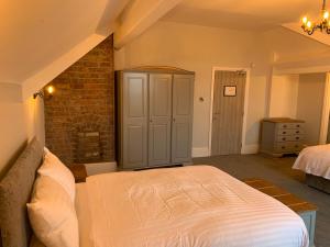 a bedroom with a bed and a brick wall at Churchill's Hotel in Wombwell