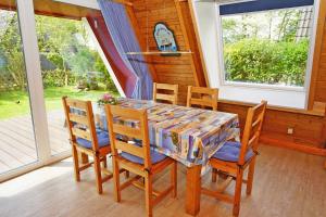a dining room with a table and chairs and windows at Urlaub fuer die ganze Familie in Damp