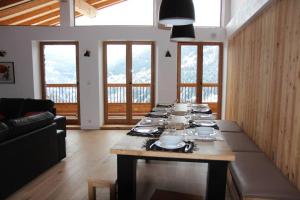 a dining room with a long table with dishes on it at Chalet avec vue imprenable in Montvalezan