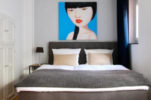 a bedroom with a bed with a painting on the wall at Arthouse Apartments im Belgischen Viertel in Cologne