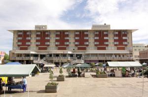 Cresta President Hotel في غابورون: مبنى كبير فيه ناس جالسين خارجه