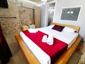 1 dormitorio con 1 cama grande con manta roja en Düşler Evim Butik Otel, en Kas