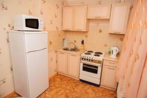 La cuisine est équipée d'un réfrigérateur blanc et d'un four micro-ondes. dans l'établissement Тараскова 4, à Tcherkassy