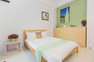 a bedroom with a bed and a table with flowers at 曉翠軒親子民宿 in Wujie