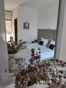 1 dormitorio con 1 cama con flores púrpuras en AFRODITI Hotel Studios, en Masouri