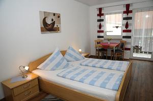 a bedroom with a bed with blue and white sheets at Landgasthaus Zum Mönchshof in Wolframs-Eschenbach
