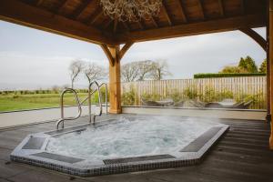a hot tub on a deck with a gazebo at Bowfield Hotel and Spa in Howwood